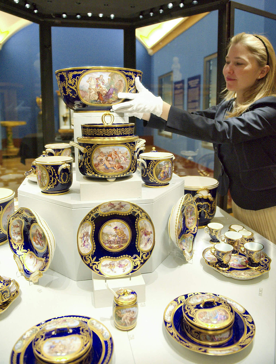 Сотрудник галереи расставляет предметы из сервиза Людовика XVI 1783-1799 гг. Севр